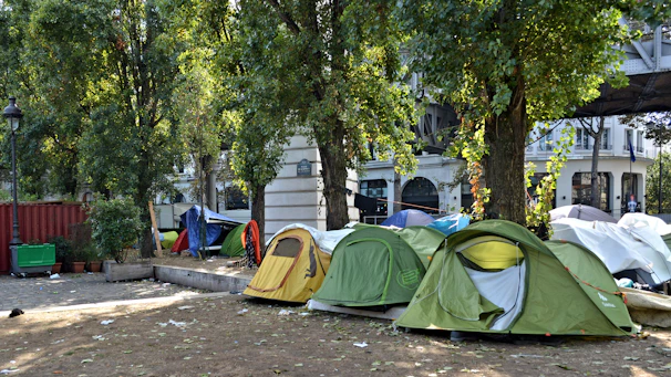 Volunteers setting up colorful booths and decorations in a sunny park.
