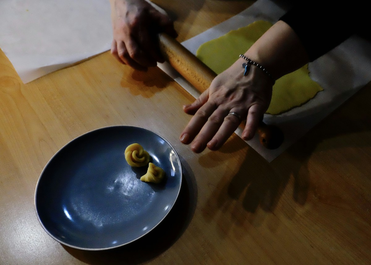 Person preparing dough with a rolling pin on a floured surface, ideal for easy tailgate recipes and game day food.