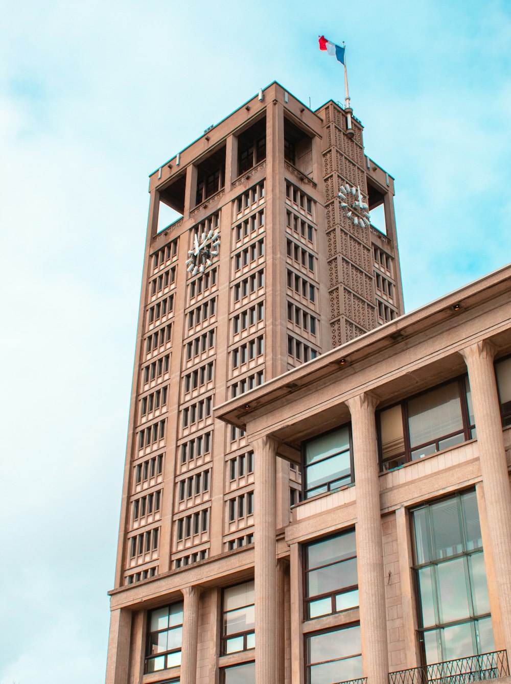 edifício de concreto marrom sob o céu azul durante o dia