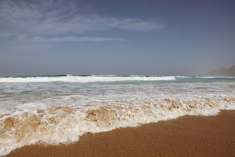 ocean waves crashing on shore during daytime