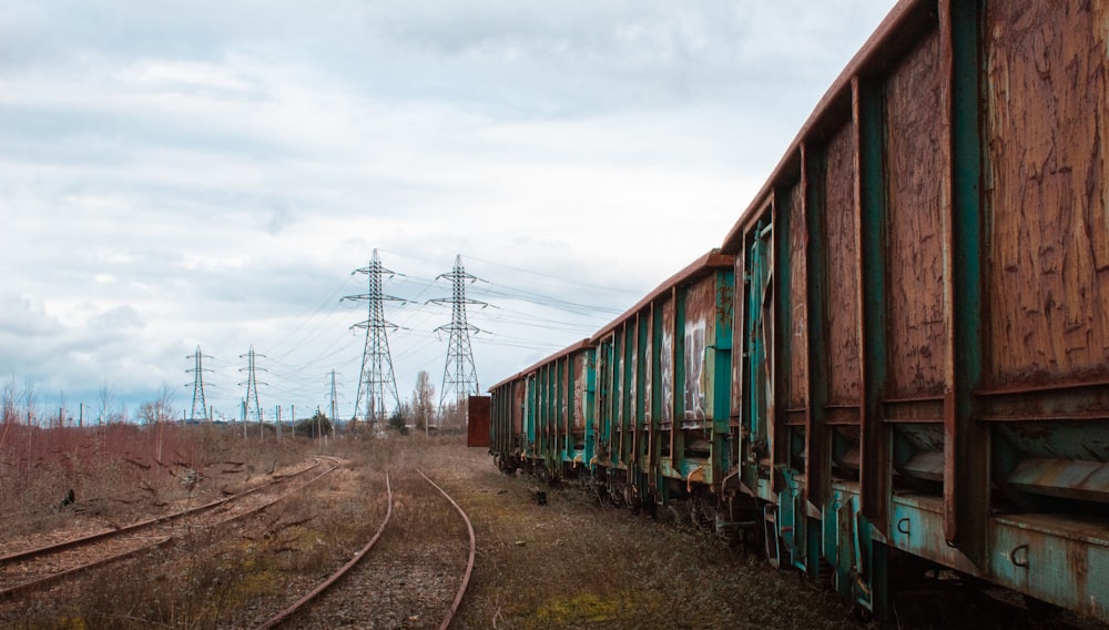 brown and green train under white clouds during daytime