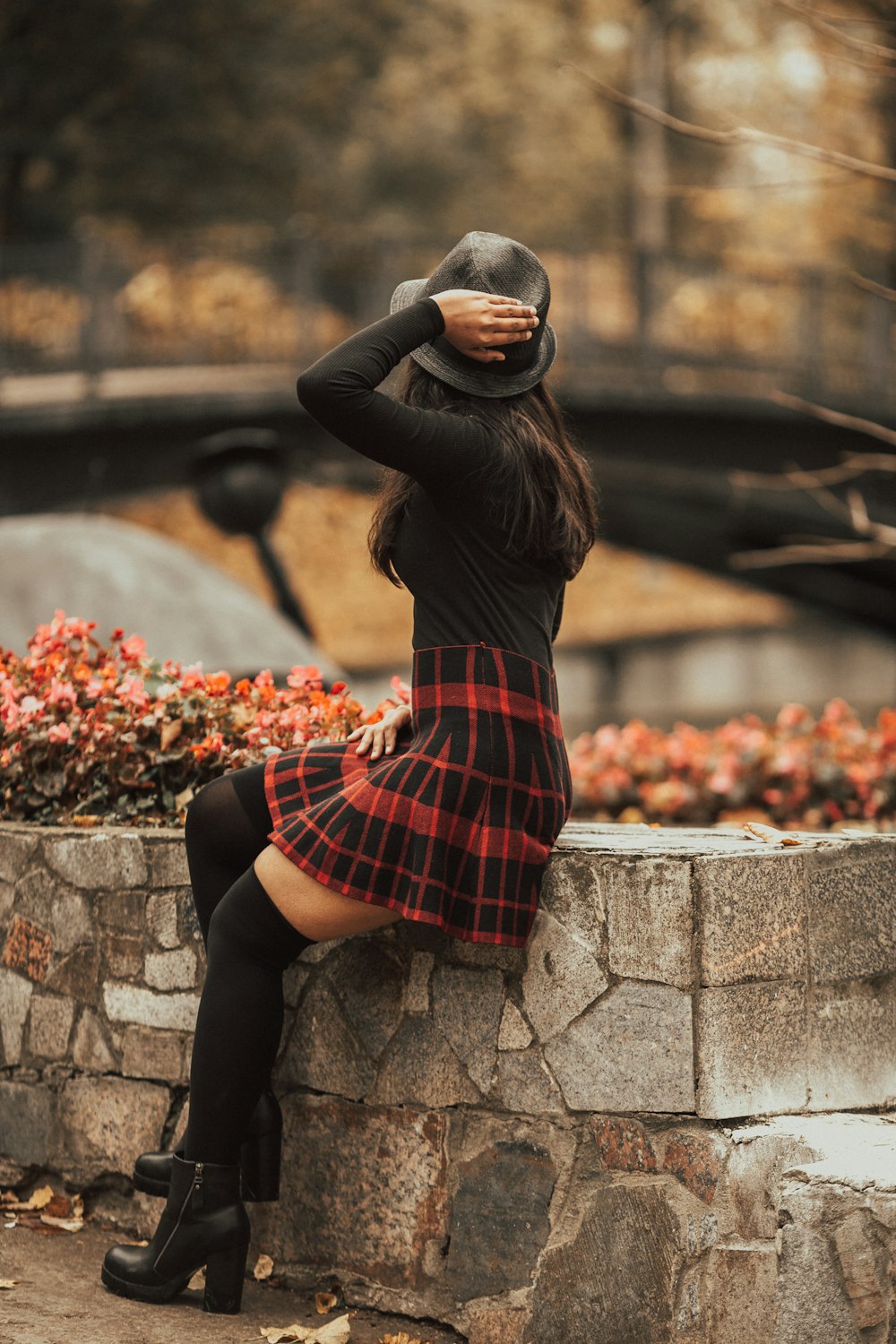 woman in black long sleeve shirt and red skirt sitting on concrete bench