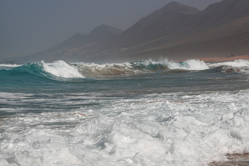 sea waves crashing on shore during daytime