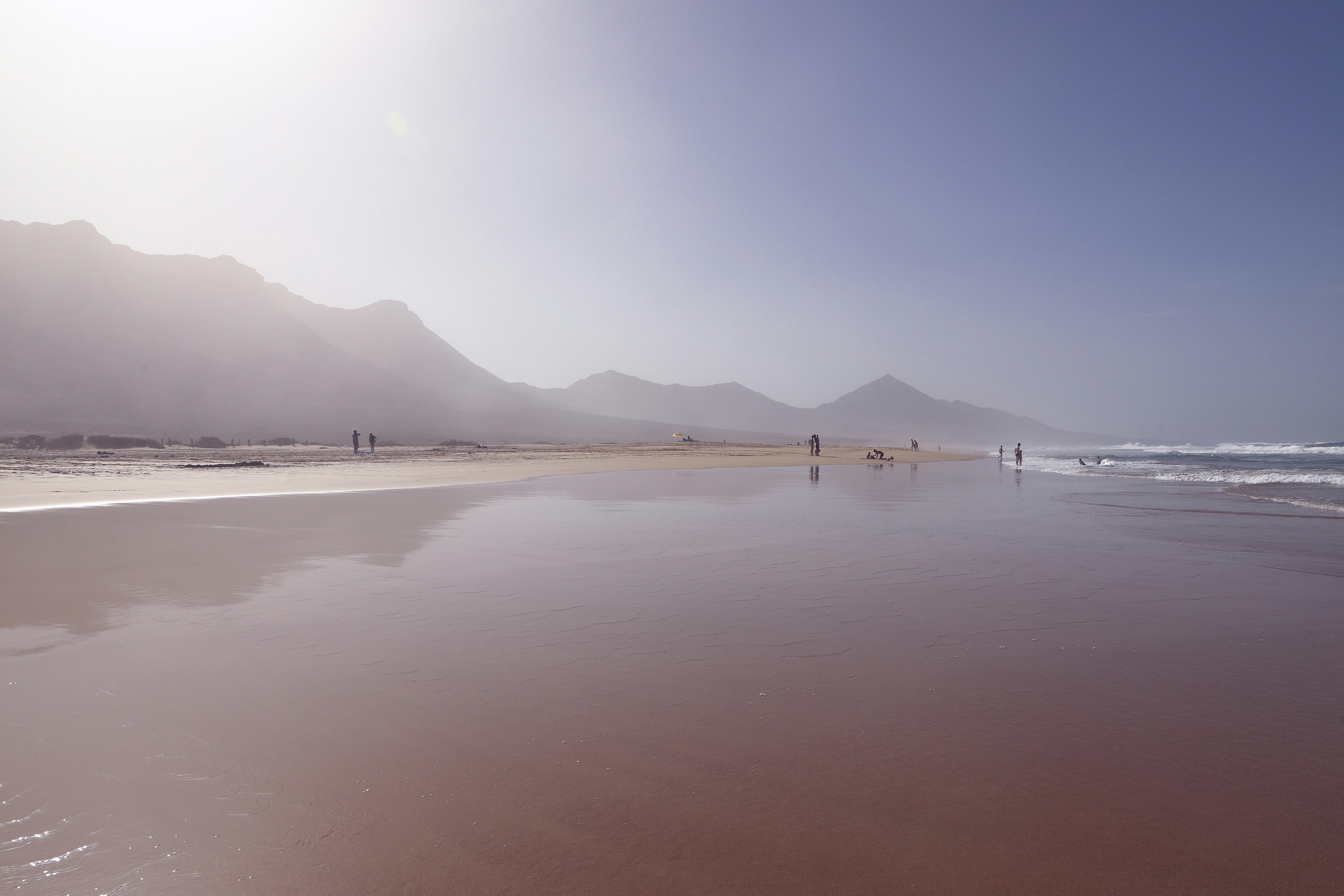body of water near mountain during daytime