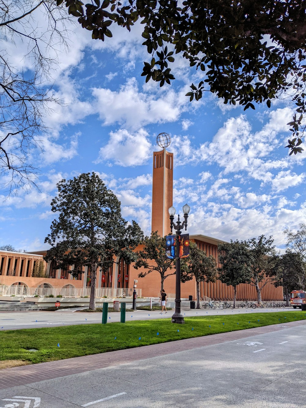 brown concrete building near green trees under blue sky during daytime