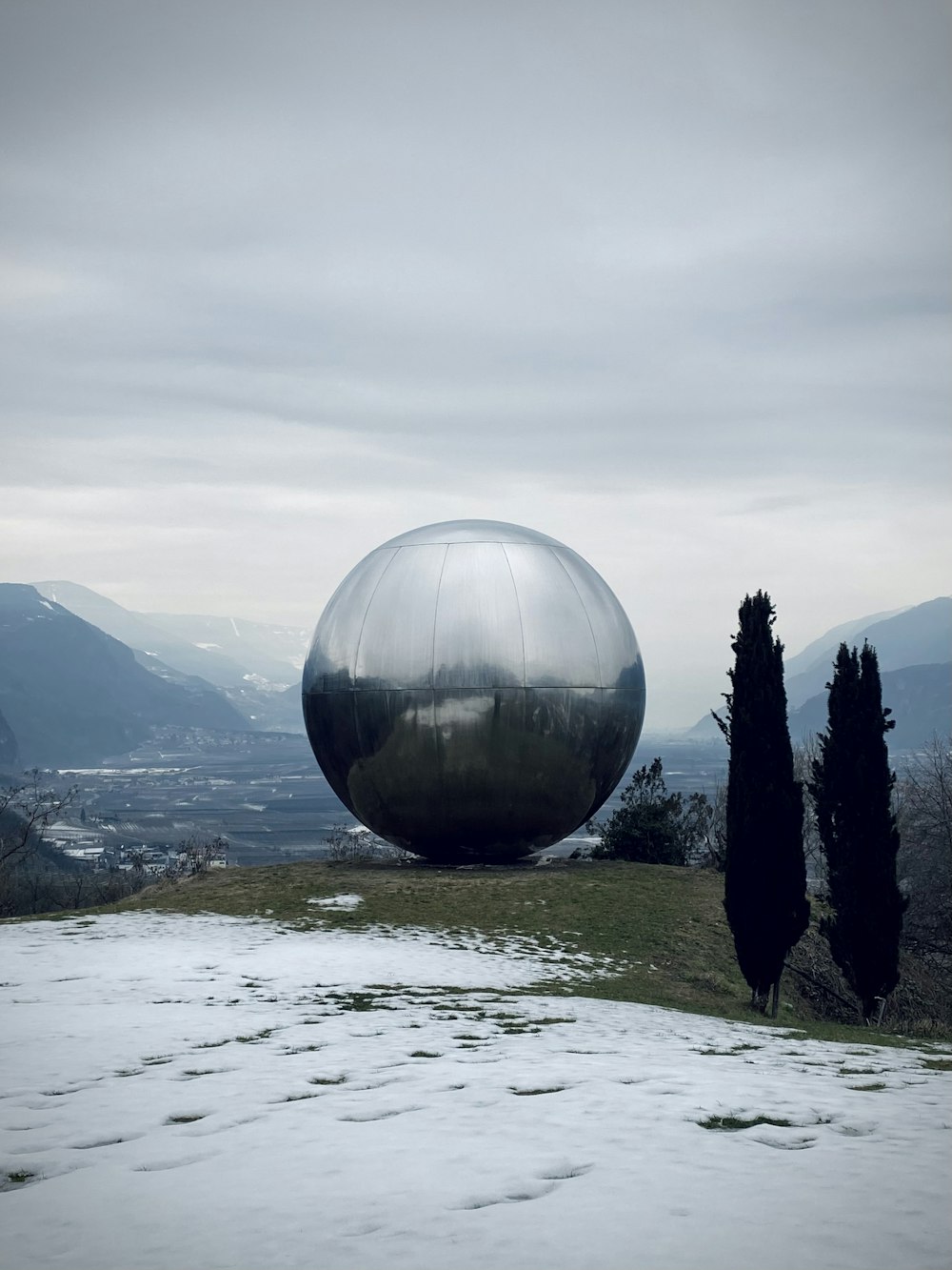 clear glass ball on green grass field near body of water during daytime