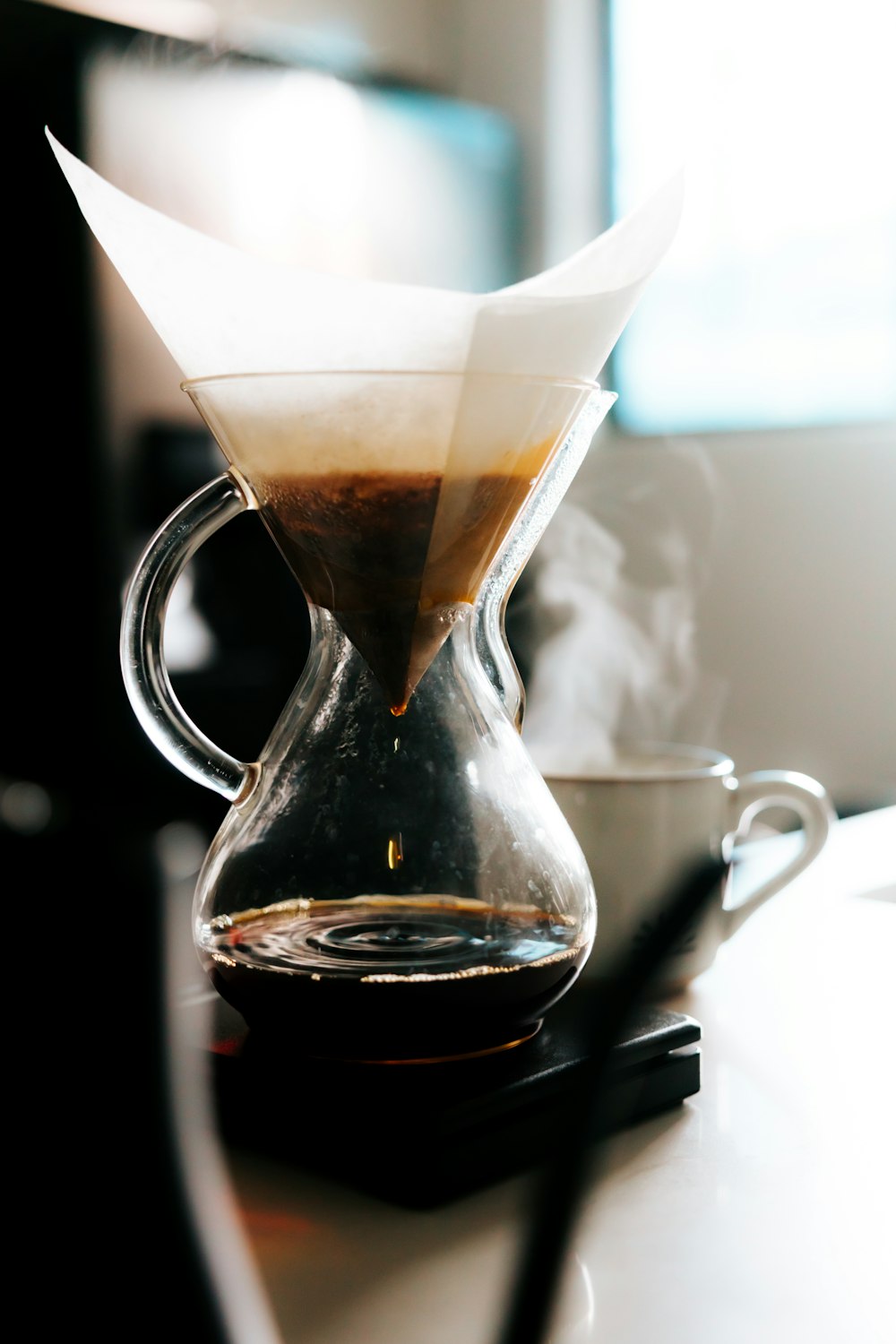 clear glass pitcher with brown liquid