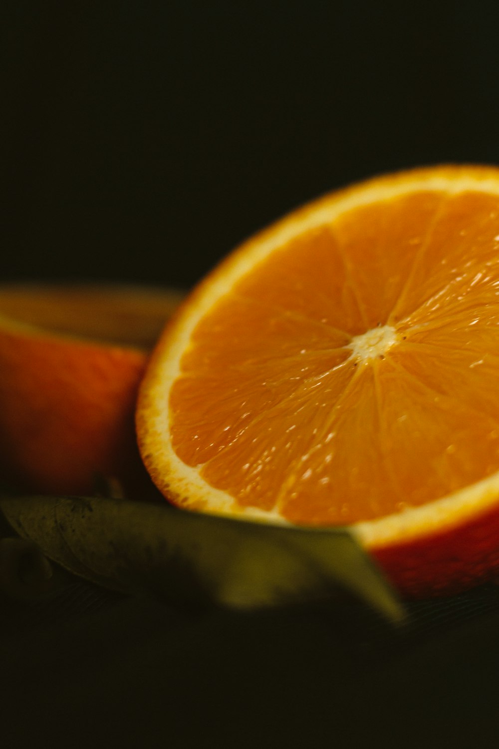 fruta laranja fatiada no fundo preto