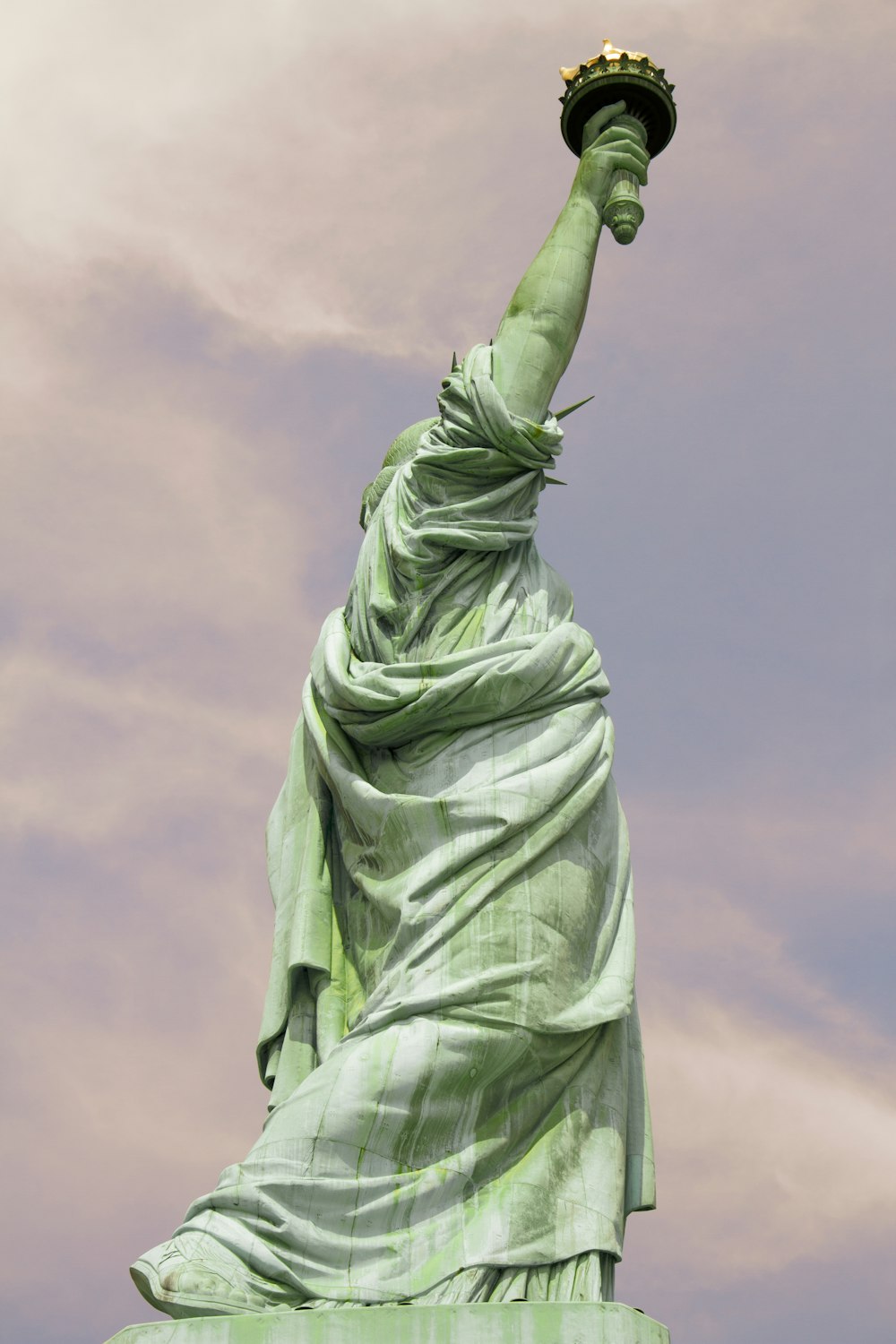 statue of liberty under cloudy sky during daytime