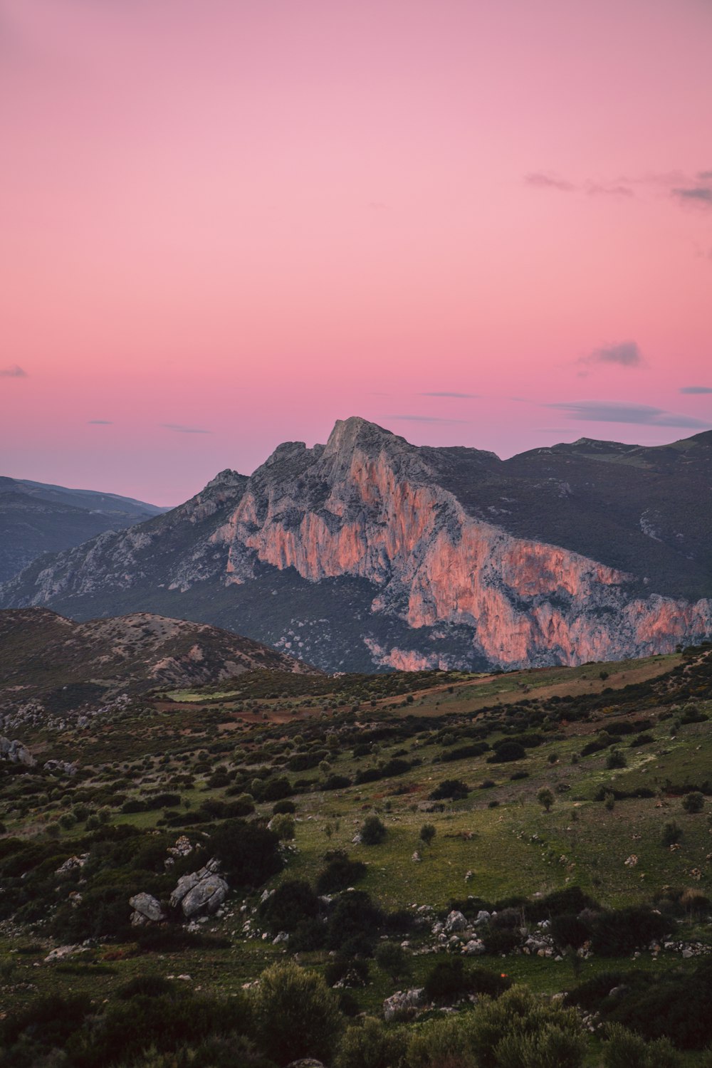 Una montagna con un cielo rosa sullo sfondo