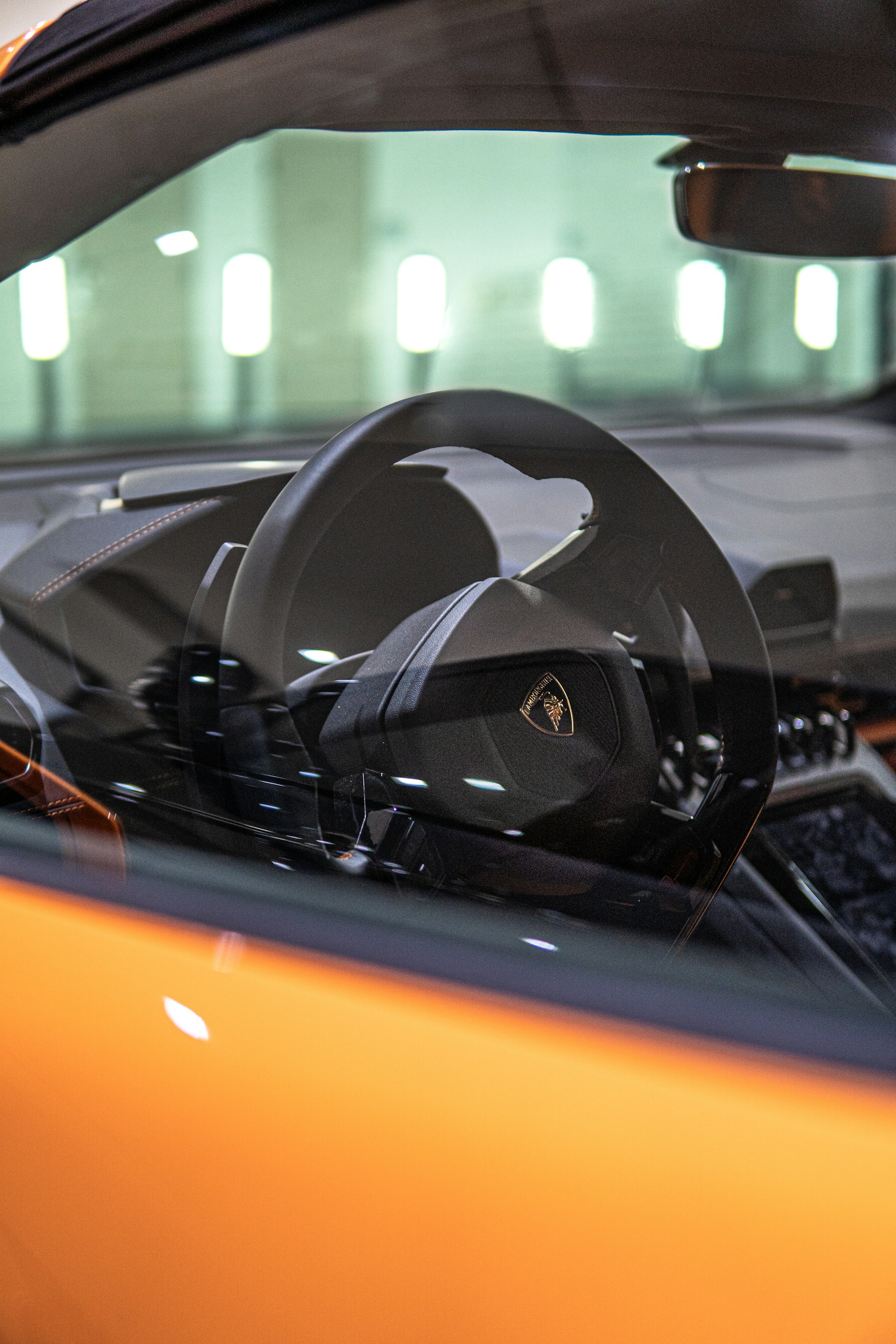 black and orange lamborghini aventador in a city