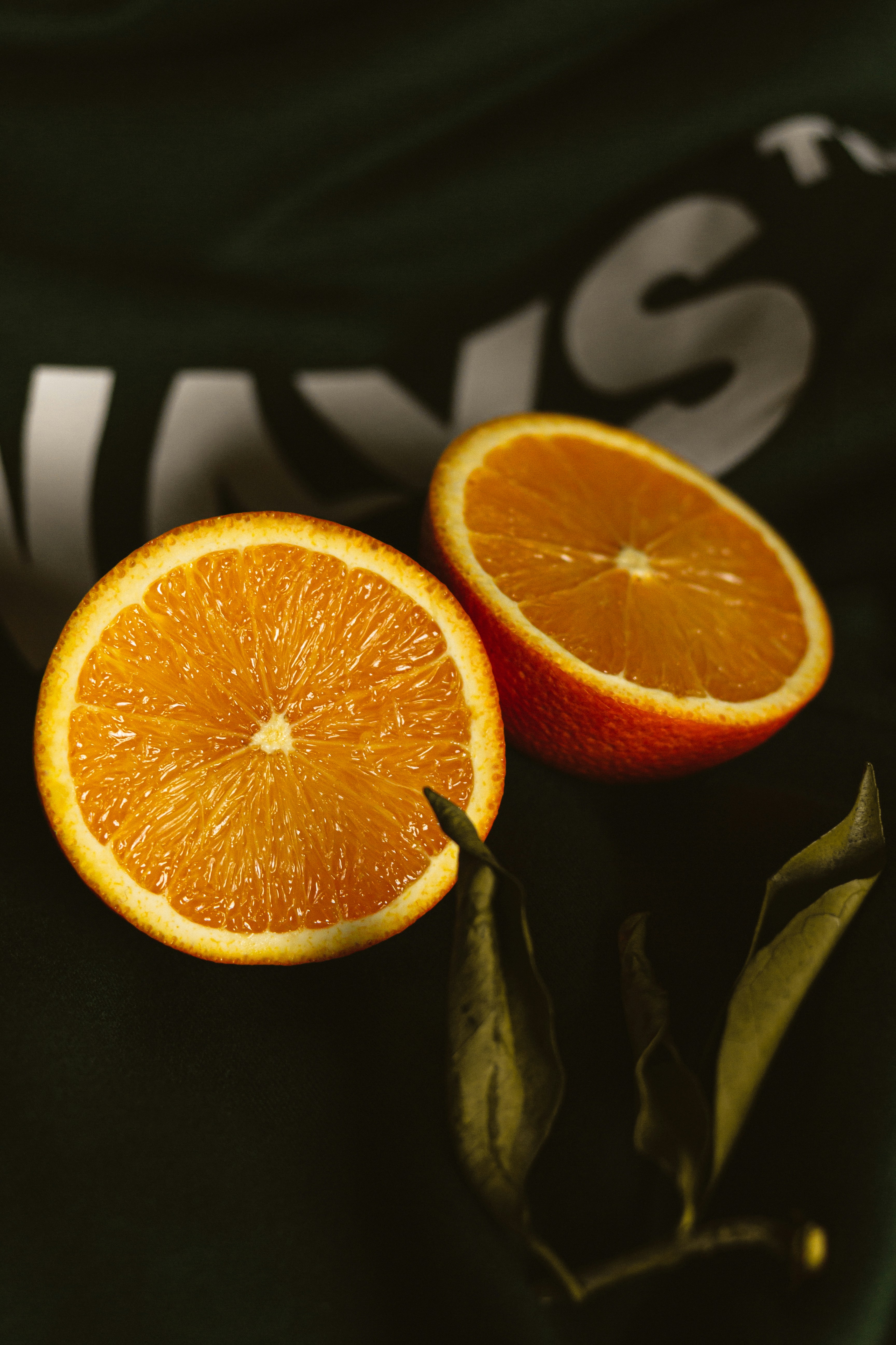 sliced orange fruit on black and white textile