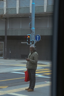 Young person using smartphone with colorful shopping bags in a bright urban setting