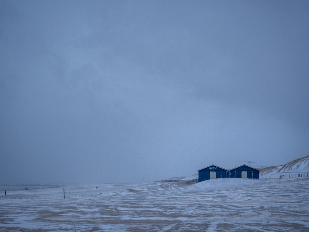 black wooden house on snow covered ground