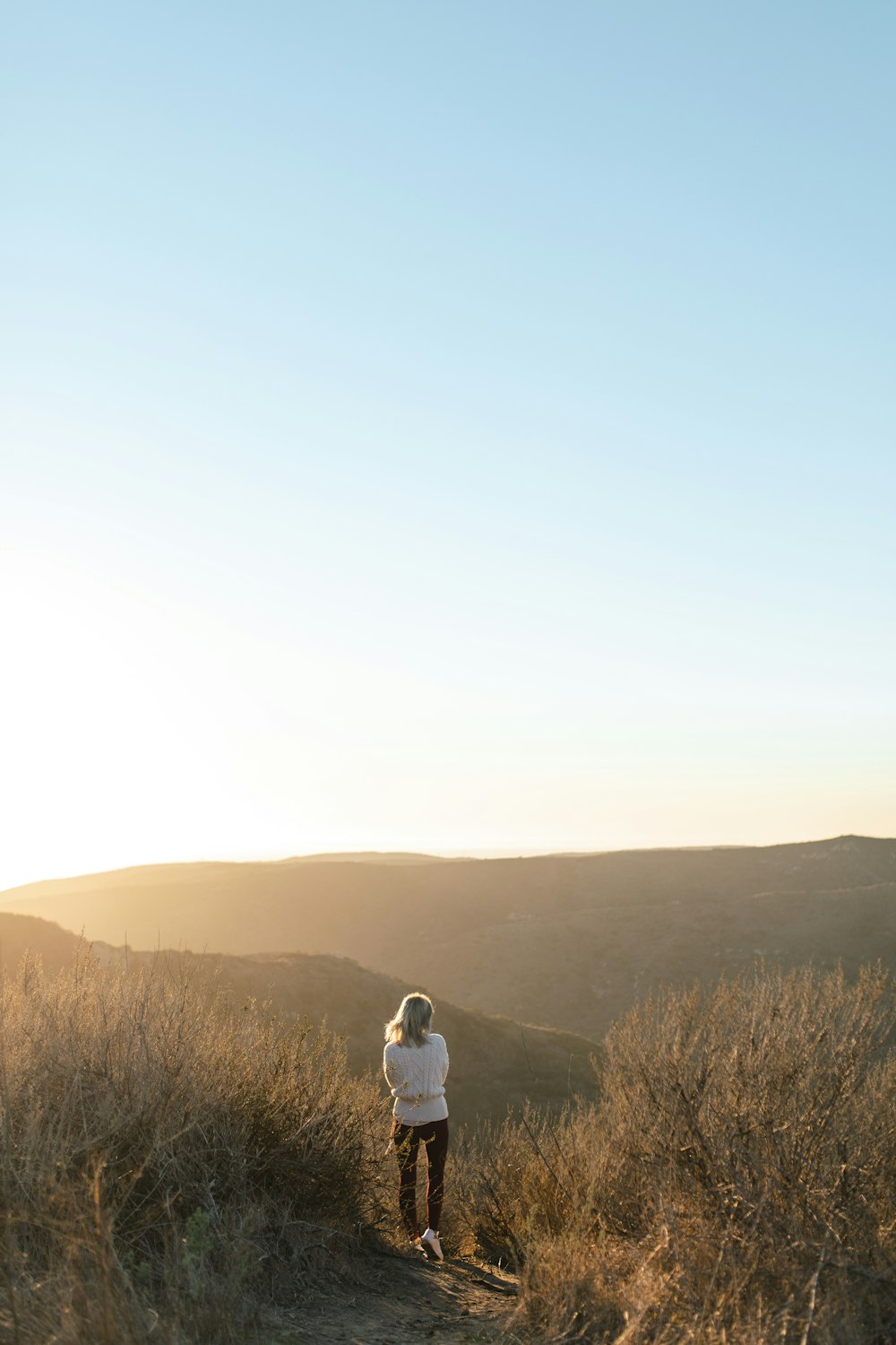 man in white shirt standing on brown grass field during daytime