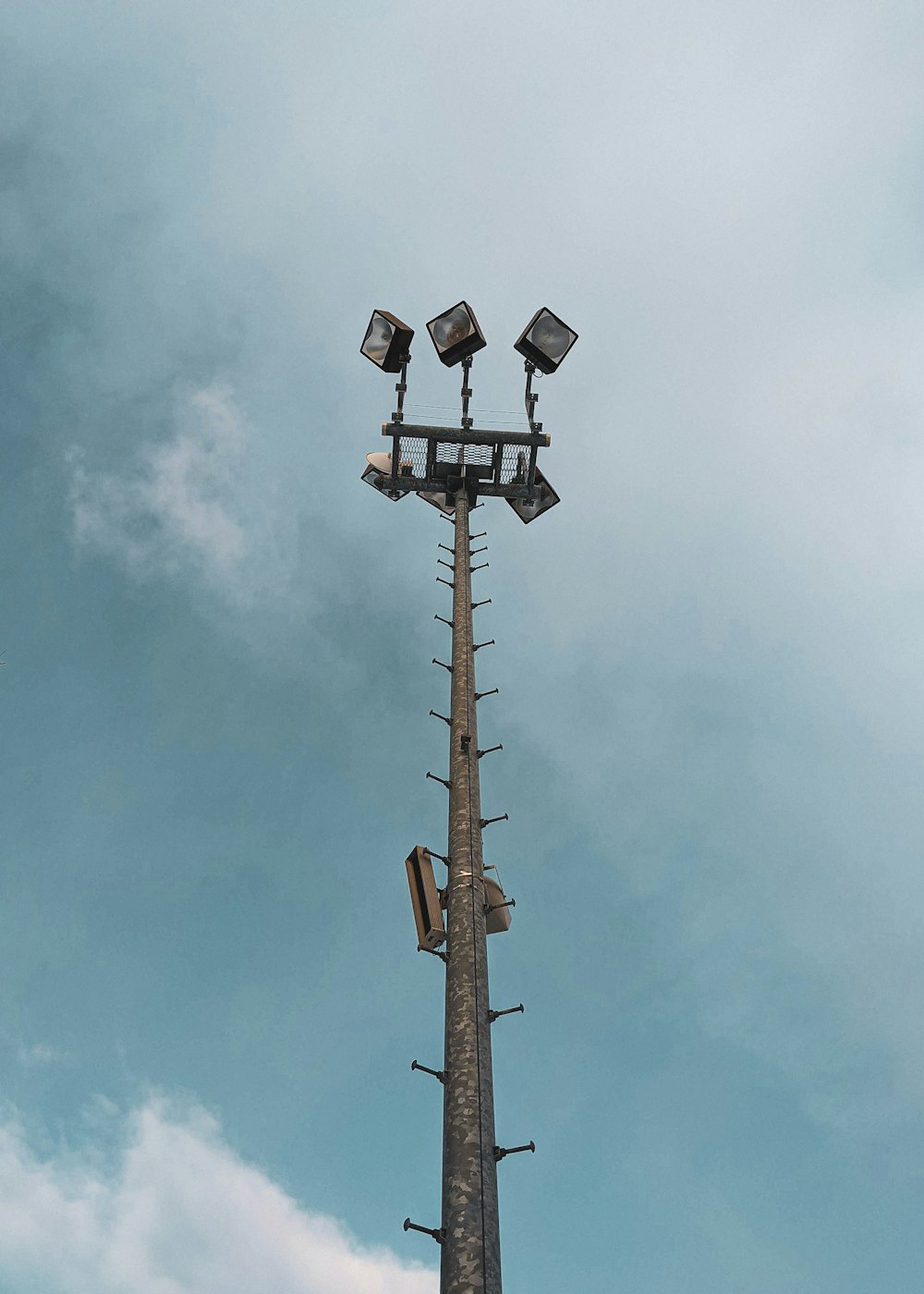 Brauner Holzstrommast unter blauem Himmel