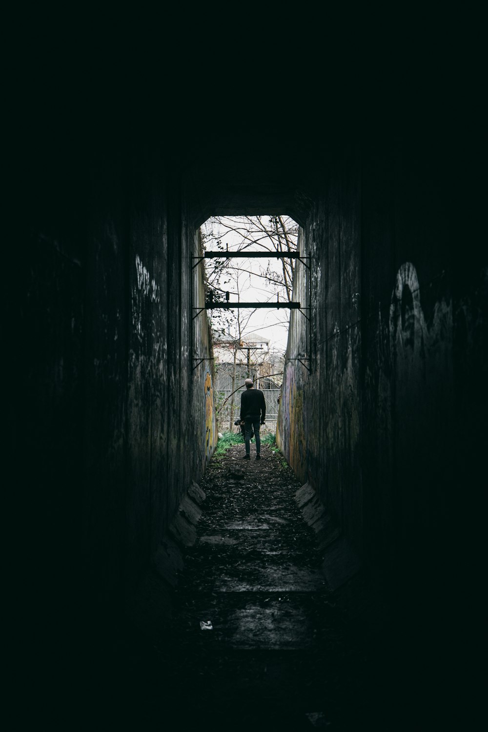 person in green shirt walking on tunnel