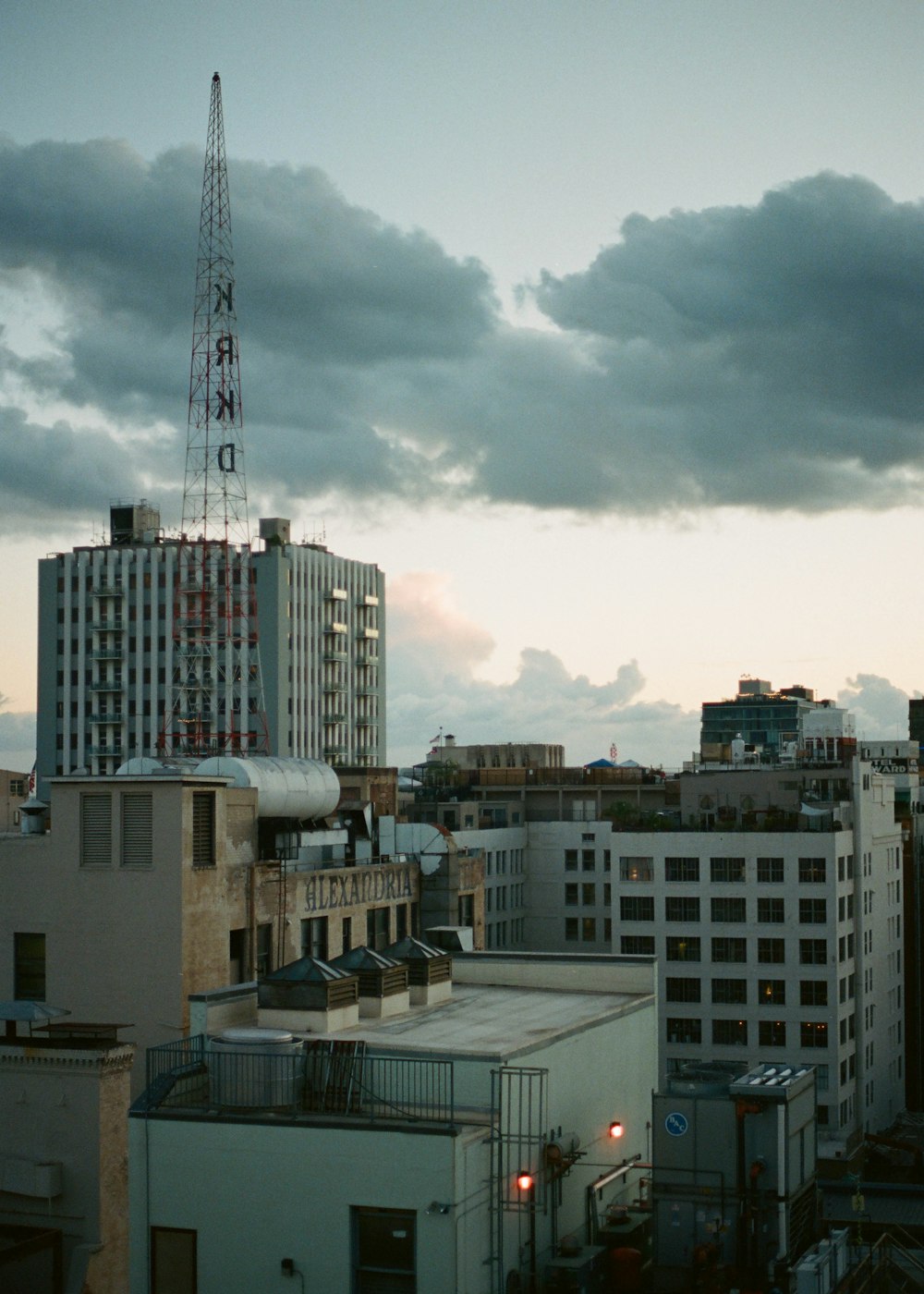 white and brown concrete buildings under white clouds and blue sky during daytime