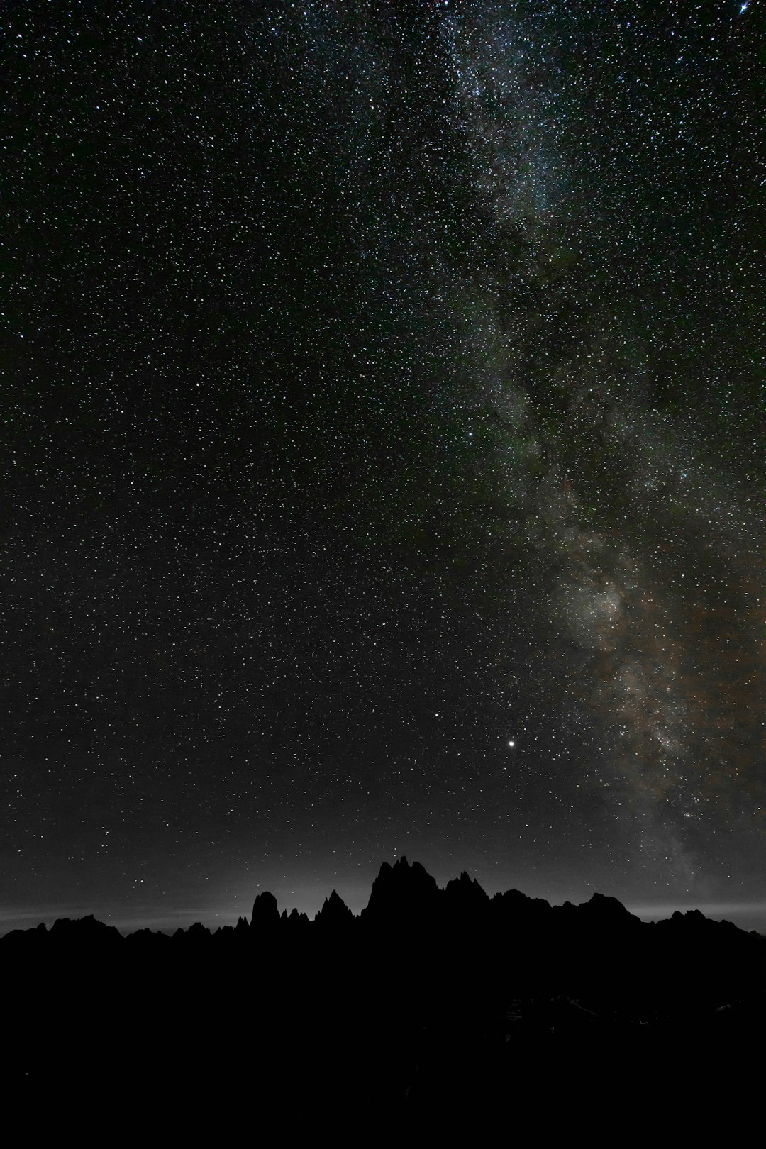 silhouette of mountain under starry night