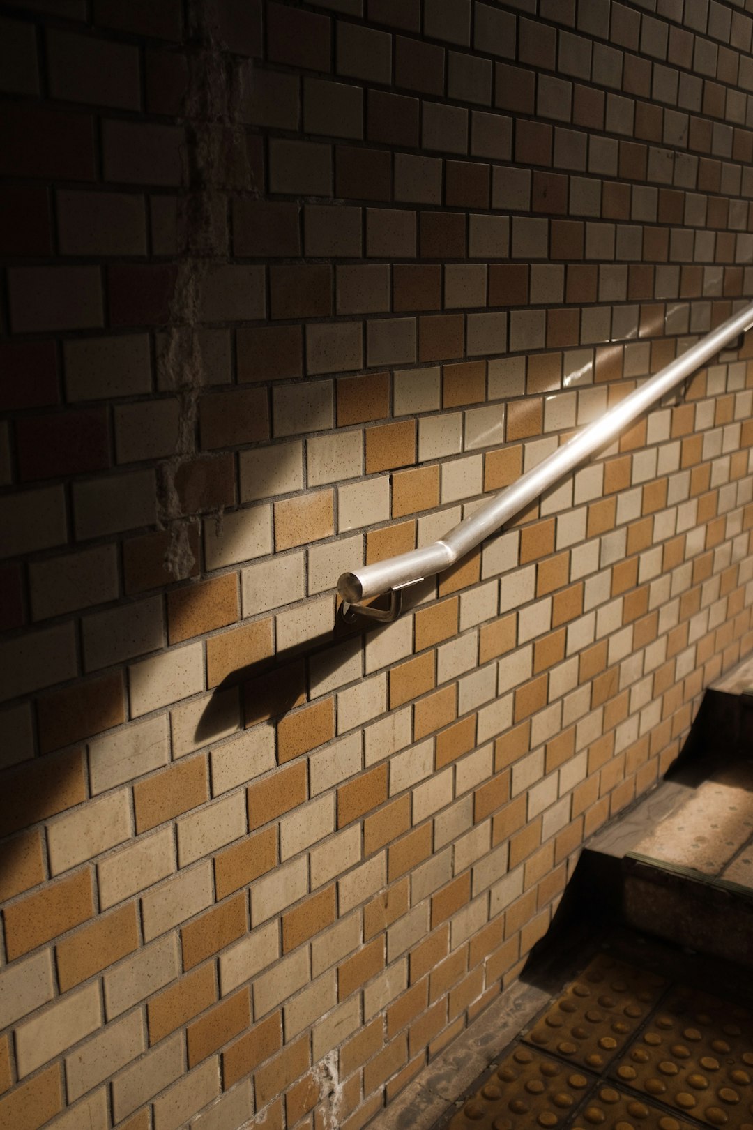 white metal pipe on brown brick wall