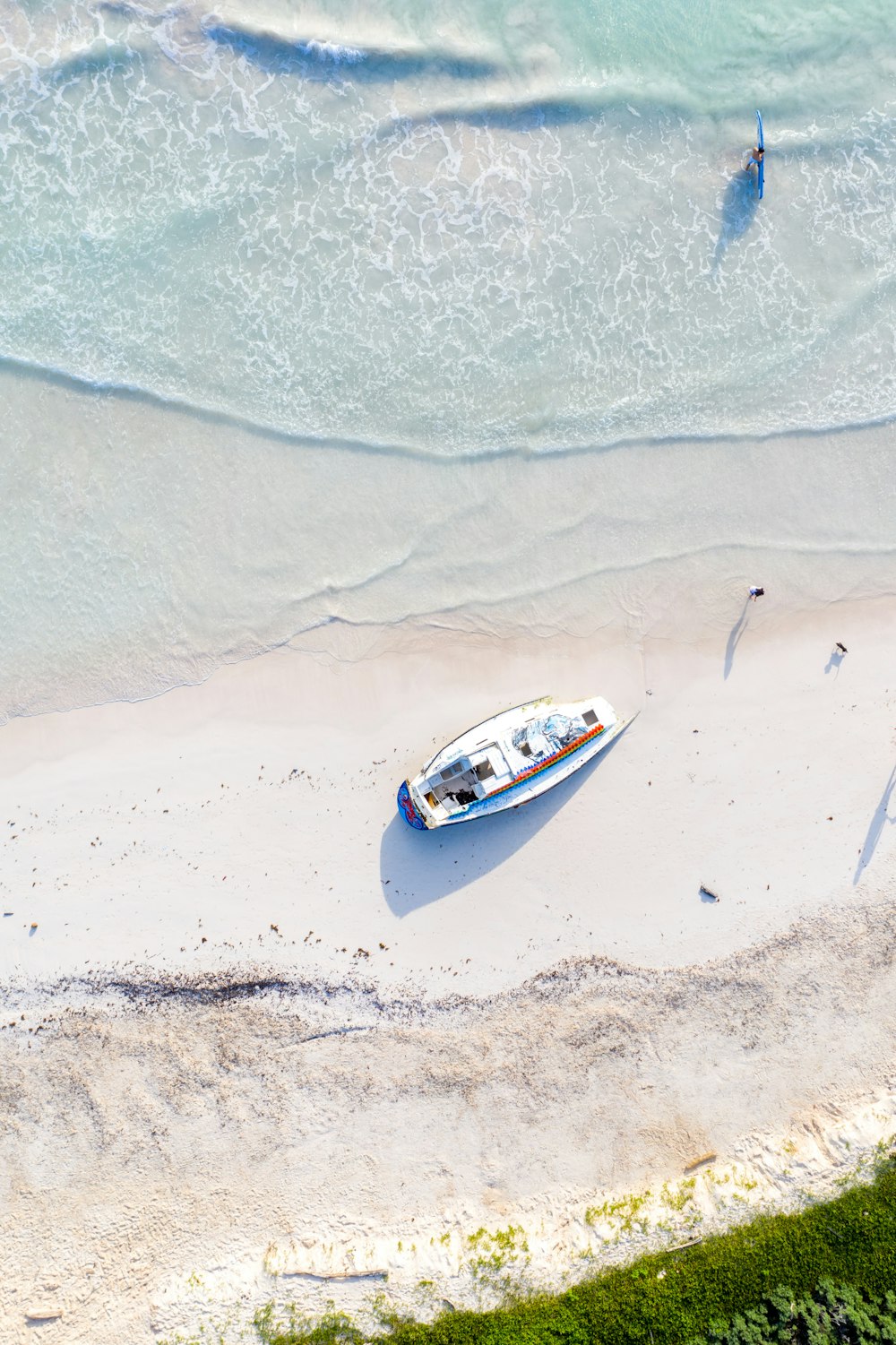 white and blue boat on beach during daytime