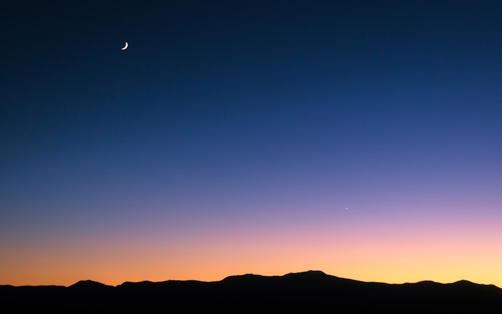 silhouette of mountain under blue sky during daytime