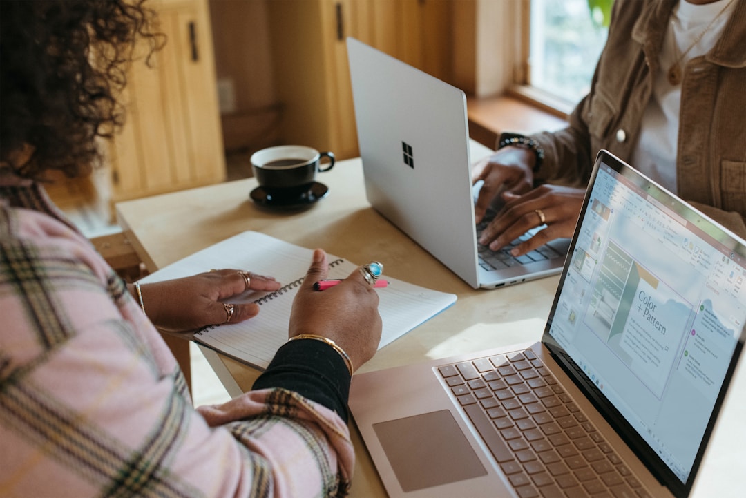 Two business professionals using laptops to review best proposal software features