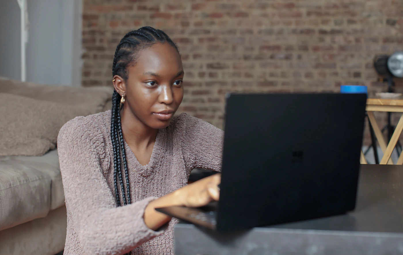 Une jeune femme travaille sur son ordinateur portable