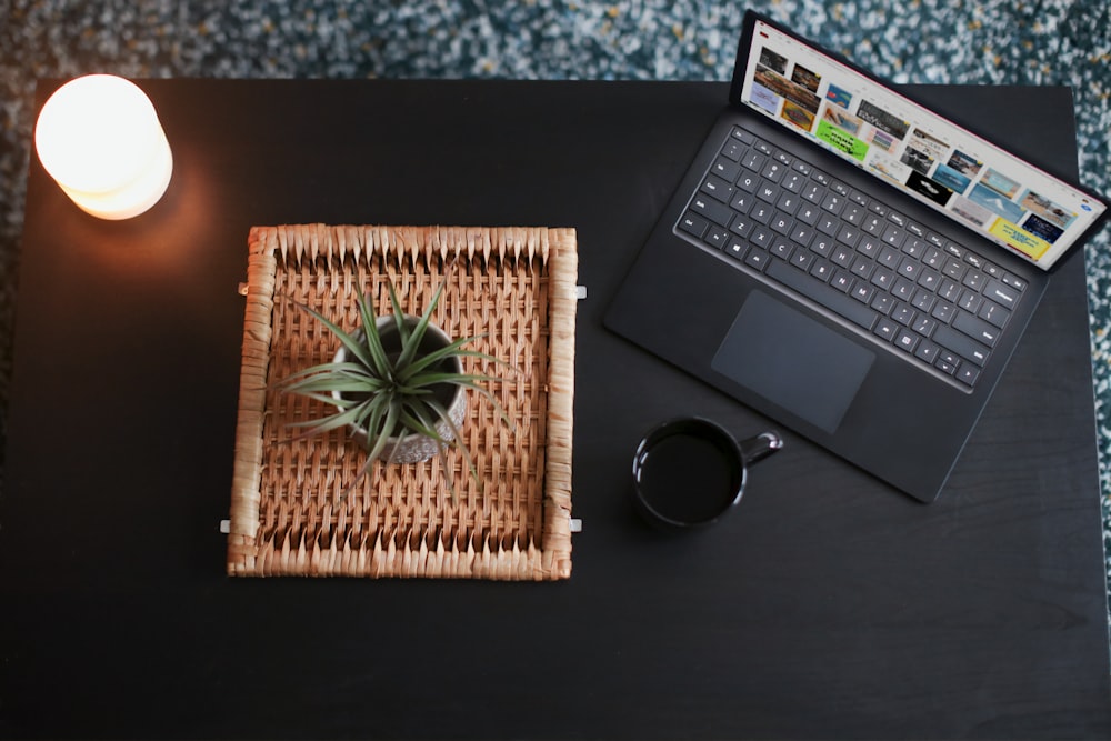 green plant on brown woven basket beside black Surface device