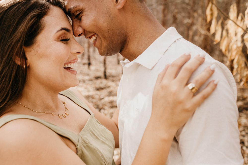 man in white dress shirt kissing woman in white sleeveless dress