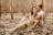 man and woman sitting on ground with dried leaves