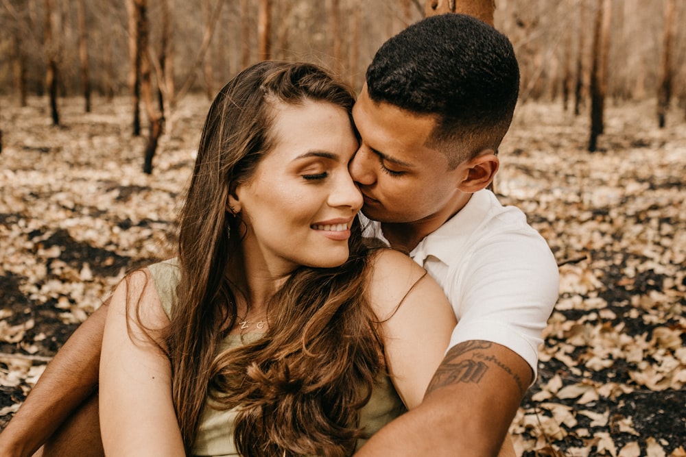 man in white dress shirt kissing woman in black tank top