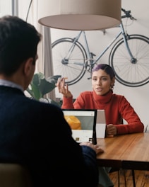 person in red sweater sitting at a table