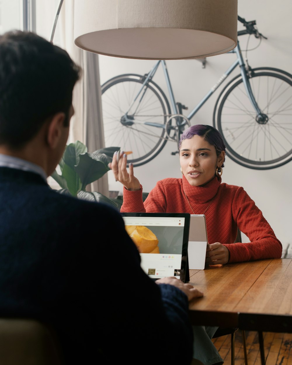 person in red sweater sitting at a table