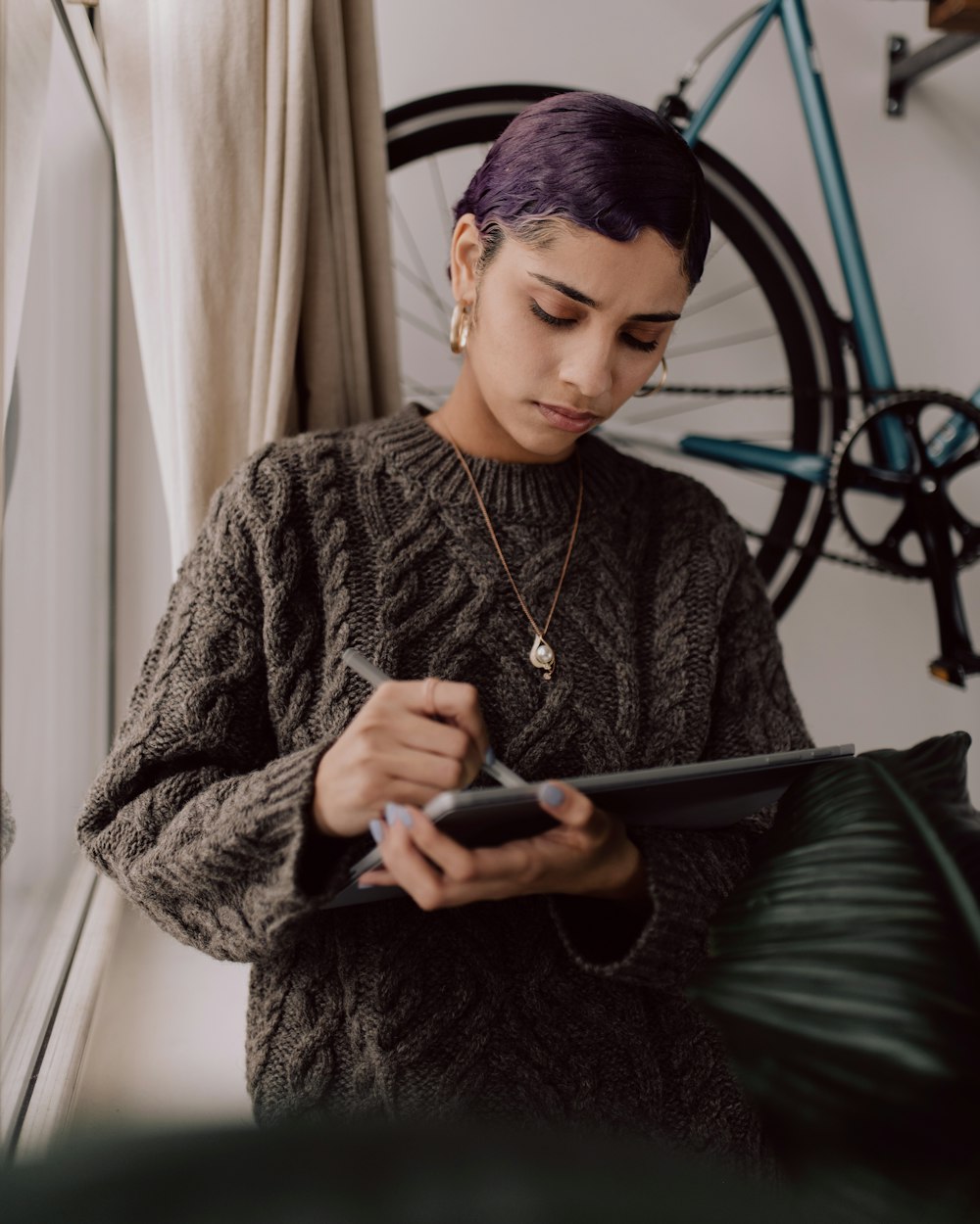 person in gray sweater holding Surface device