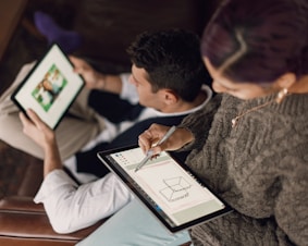 person in gray sweater holding Surface devices