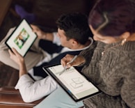person in gray sweater holding Surface devices