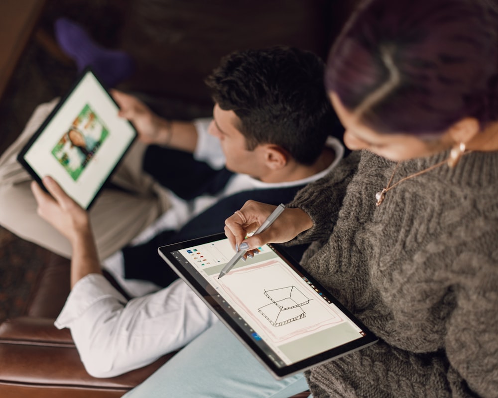 person in gray sweater holding Surface devices