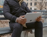 An individual using a tablet in a vibrant urban setting.