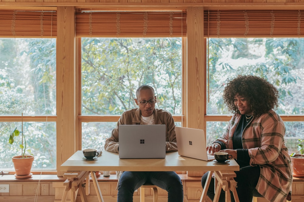 two people sitting on chair in front of Surface devices