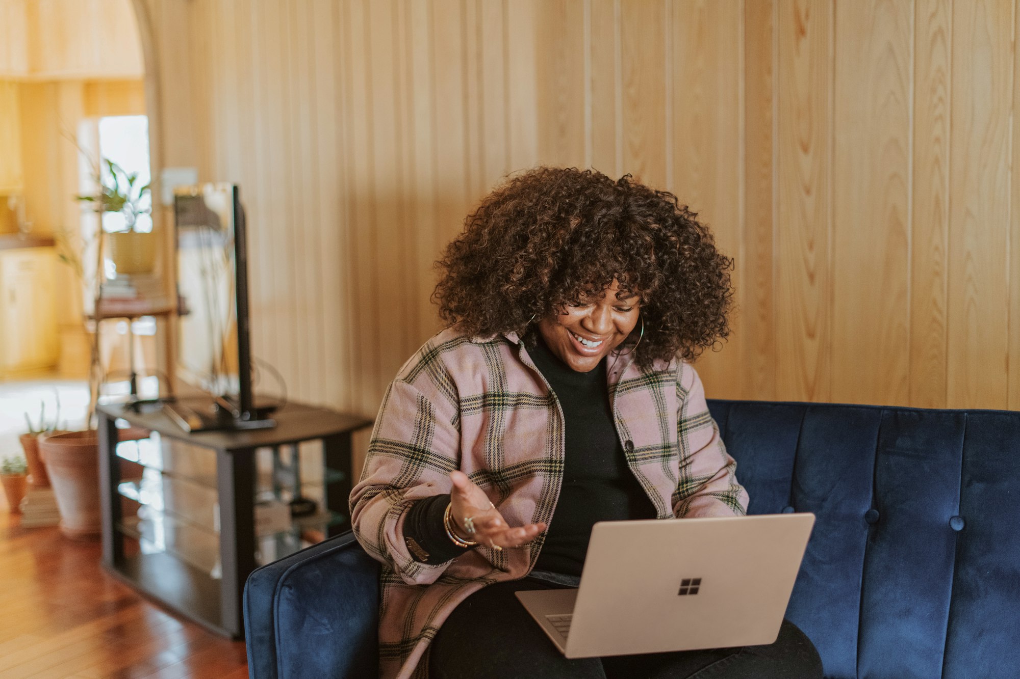 Woman having a video call on a blue couch