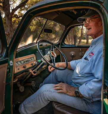 man in blue button up shirt driving car during daytime