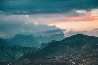 A serene landscape showing shifting weather patterns under a dramatic sky.