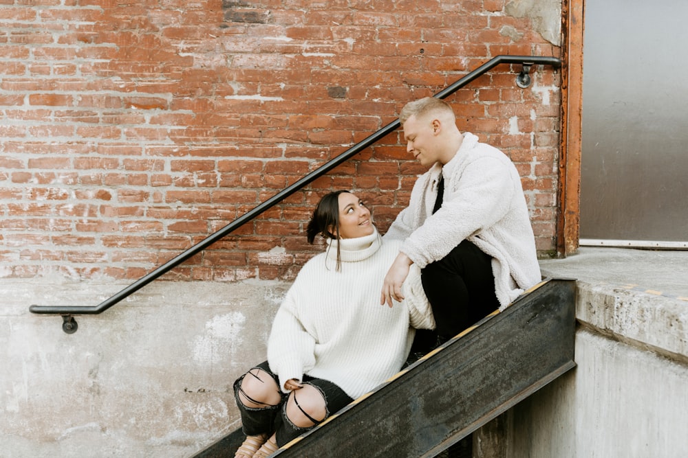 girl in white sweater and black sunglasses sitting on brown wooden staircase