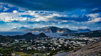 green grass field near body of water under blue sky during daytime