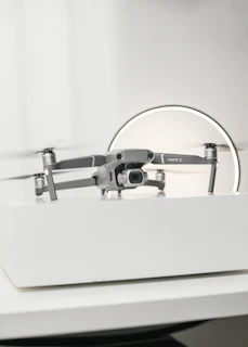 Close-up of a sleek drone accessory resting on a sky-blue fabric backdrop.