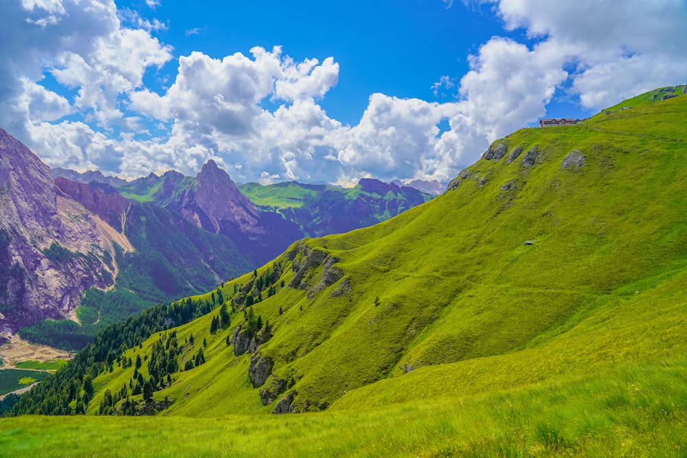 green mountains under blue sky and white clouds during daytime