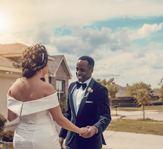 woman in white wedding dress holding man in black suit