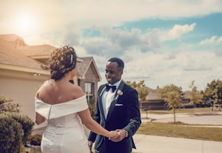 woman in white wedding dress holding man in black suit