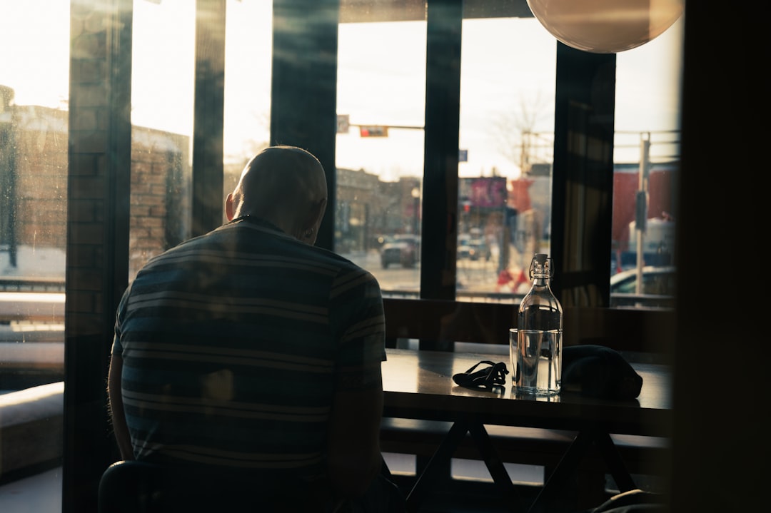 man in white and black striped long sleeve shirt sitting on chair